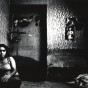Woman sitting on bed in room with posters, photo from Kaveh Golestan's Prostitute series, 1975-77